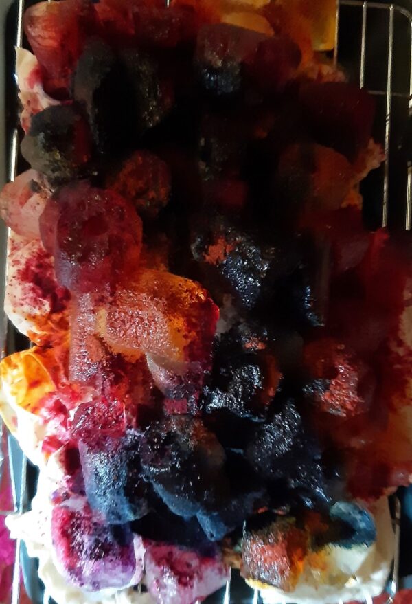 Powdered dyes sprinkled over ice cubes, with undyed fabric underneath absorbing the dyes