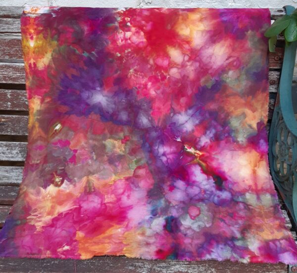 Dyed fabric in golds, reds, purples. Ice dyeing creates mottled expanses of colour which blend into each other