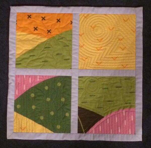 walking foot quilting sample demonstrating wiggly starburst, concentric circle and triangle, straight and wiggly lines