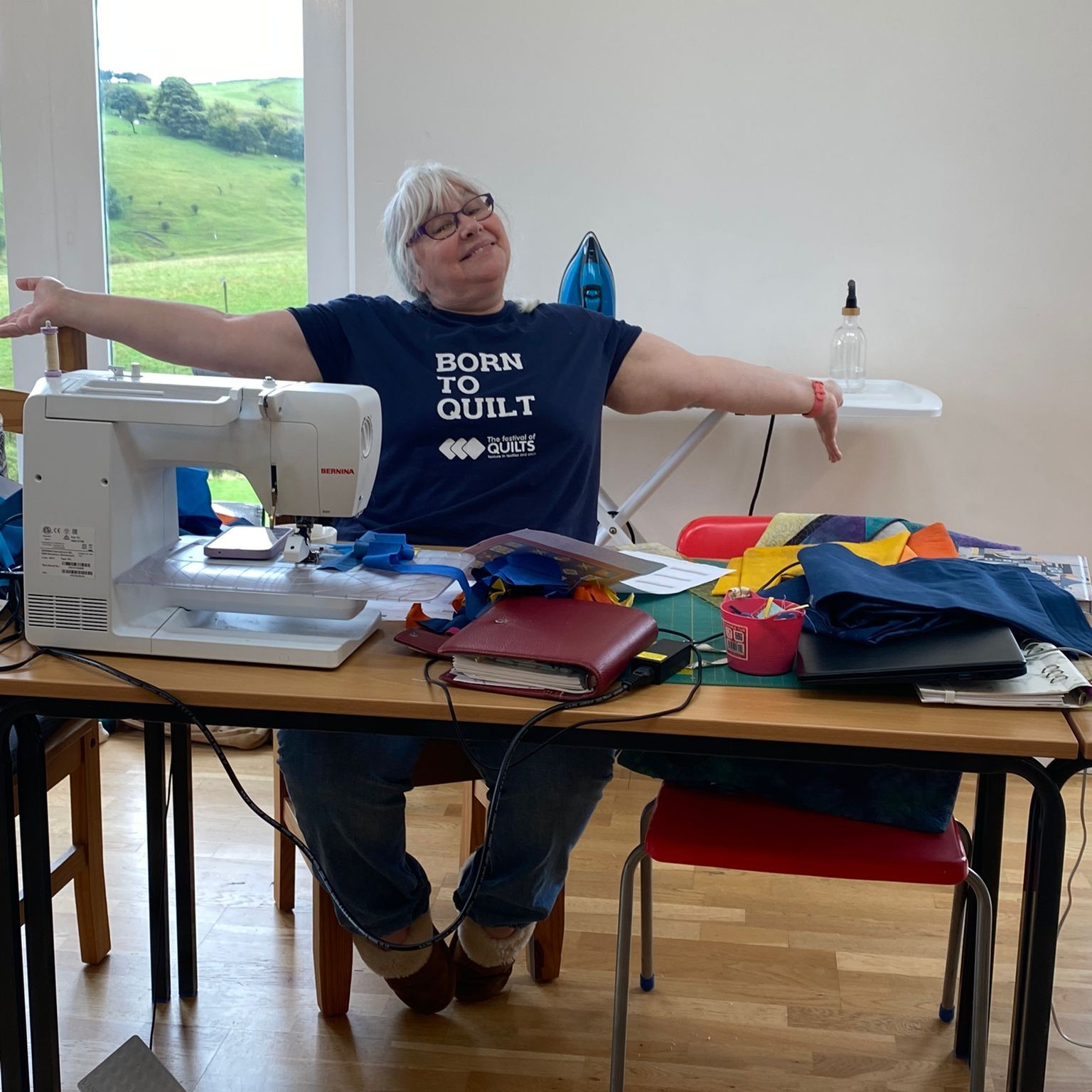 Sheena at her sewing machine wearing a t-shirt - Born to Quilt